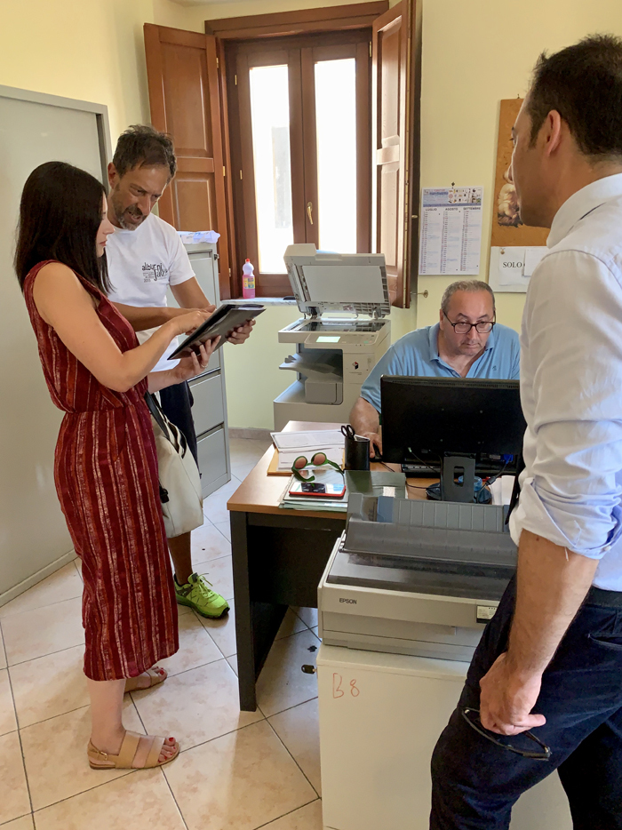 Michelle and a man look at a document in an office.