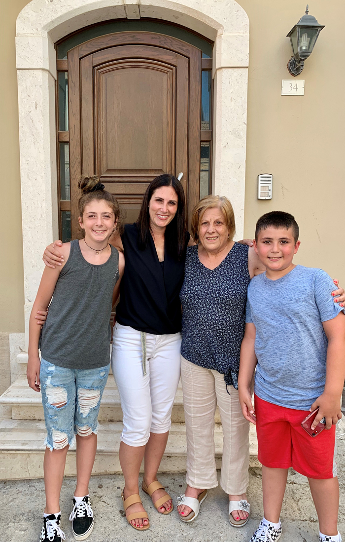 Four people (Michelle and Lucia at center) smile and pose in front of a door