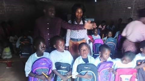 A group of children pose with backpacks